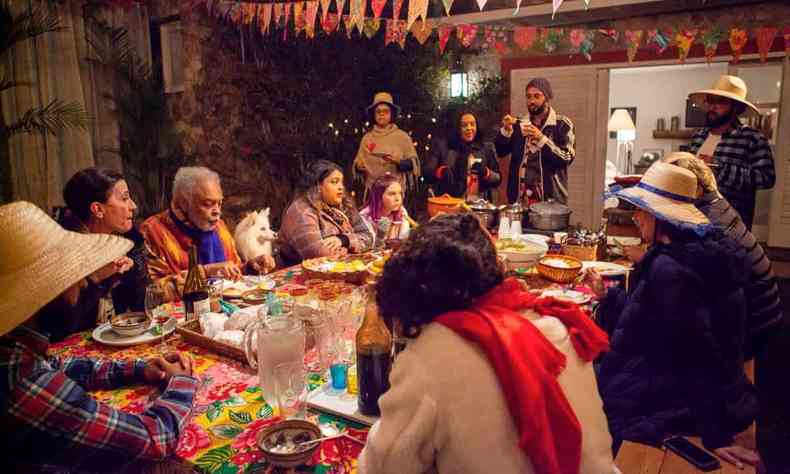 Gilberto Gil, seus familiares e um pet, à mesa com decoração de festa junina