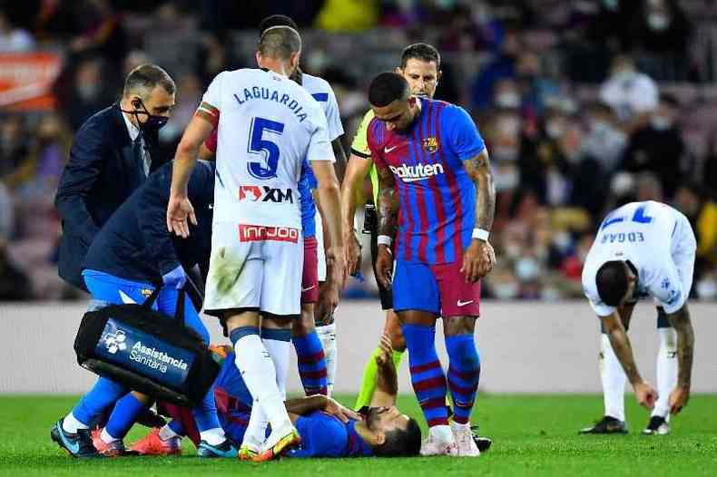 Médicos atendem o atacante argentino do Barcelona Kun Agüero durante a partida contra o Deportivo Alavés no estádio Camp Nou de Barcelona, em 30 de outubro de 2021 