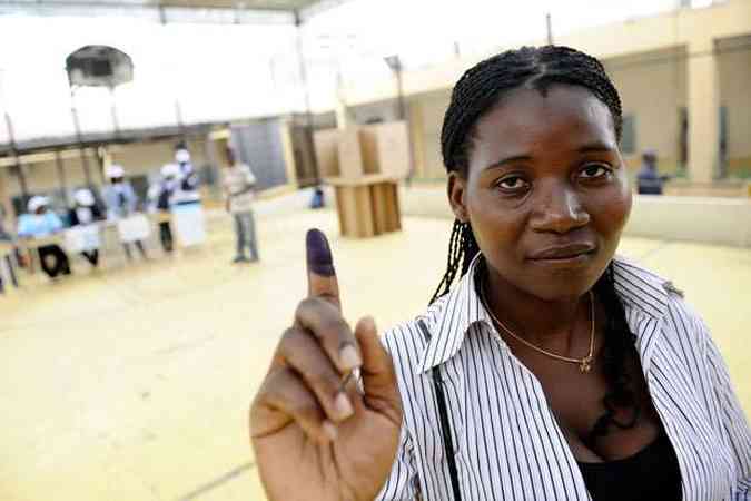 Aps votar nas eleies presidenciais de Angola, mulher mostra o dedo sujo de tinta, usada para identificar dos eleitores(foto: STEPHANE DE SAKUTIN / AFP)