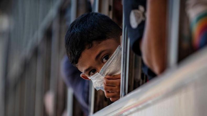 Um menino usando uma mscara espia pela janela de um nibus prestes a deixar Manila antes de um lockdown em 13 de maro de 2020 na cidade de Quezon, Metro Manila, Filipinas