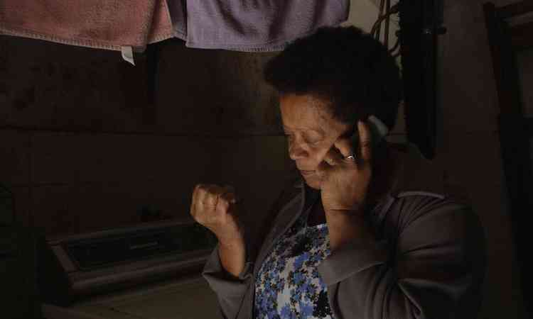 Dona Zez olha para as unhas e fala ao telefone em cena do filme Quintal