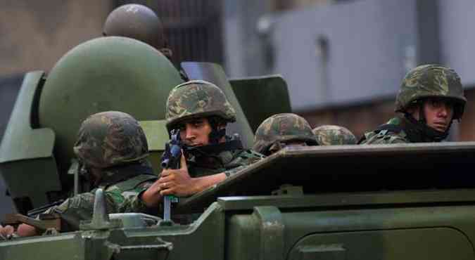 CHRISTOPHE SIMON / AFP(foto: Soldados do exrcito durante ocupao de favelas no Rio de Janeiro)