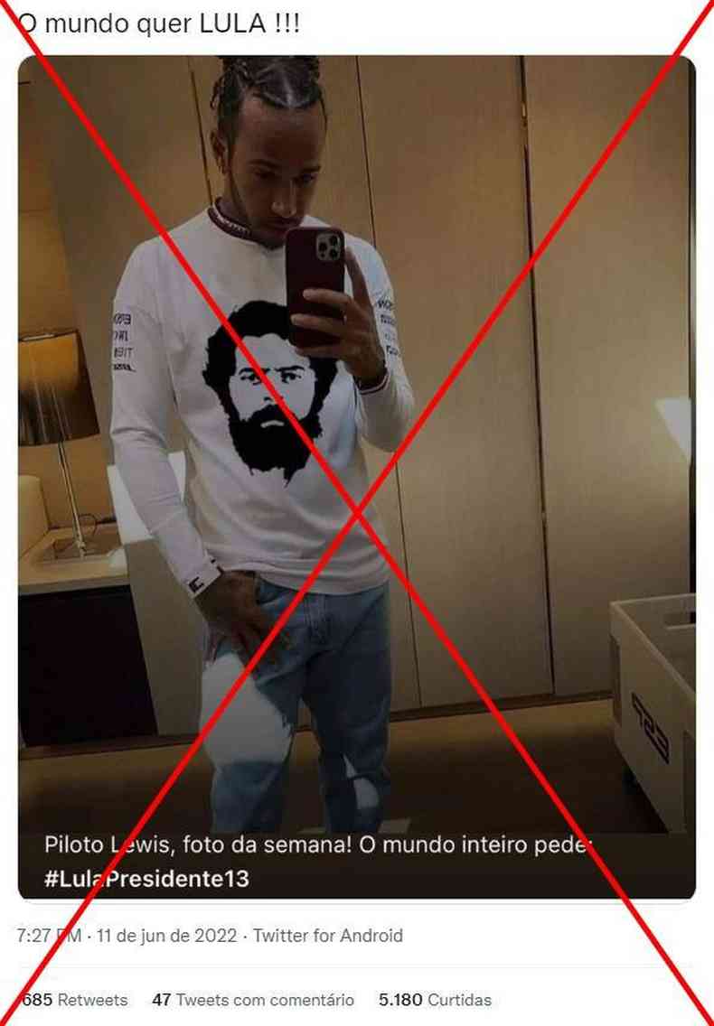Foto de Lewis Hamilton fazendo selfie com camisa estampada com o rosto do Lula com um x vermelho para mostra que  falsa