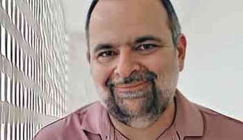 O escritor Carlos Marcelo sorri, olhando para a cmera