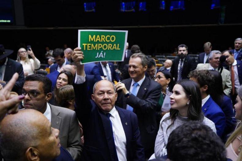 O deputado Coronel Chrisstomo (PL-RO) levanta cartaz favorvel ao marco temporal durante votao na Cmara