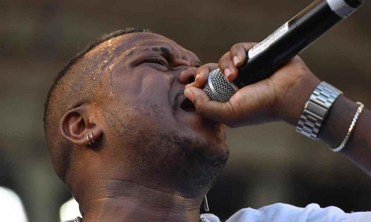 Djonga canta com o microfone colado  boca