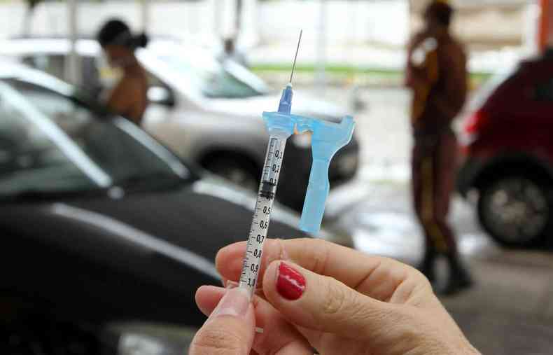Uma mo segurando uma seringa da vacina contra a COVID-19