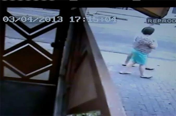 A c�mera de vigil�ncia de um pr�dio vizinho ao ambulat�rio registrou a mulher andando minutos antes de passar mal(foto: Reprodu��o)