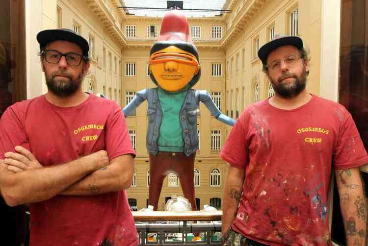 Os artistas Gustavo e Otvio Pandolfo em sacada do CCBB-BH, com a escultura Gigante ao fundo