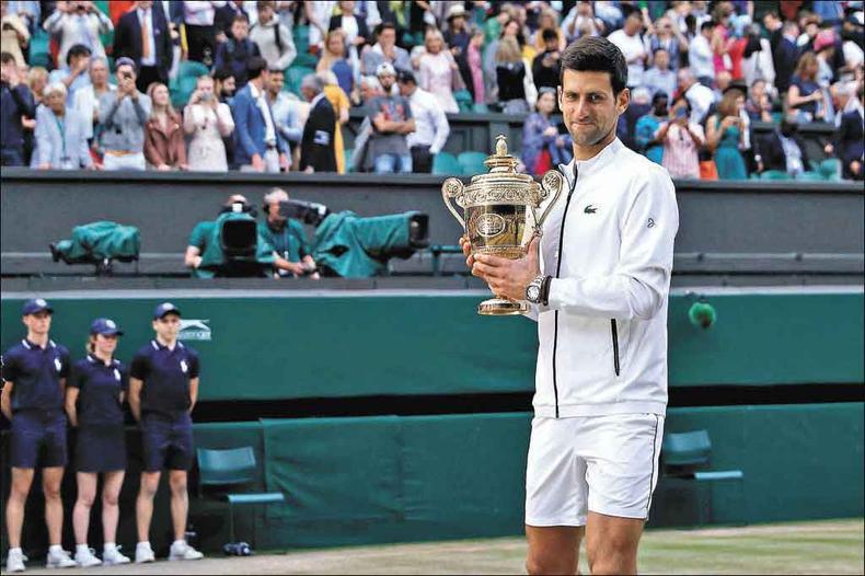 Djokovic comeu grama depois da vitória sobre Federer por 3 a 2, em 4h55min de jogo. O suíço chegou a ter dois match points e desperdiçou(foto: ADRIAN DENNIS/AFP) Djokovic comeu grama depois da vitória sobre Federer por 3 a 2, em 4h55min de jogo. O suíço chegou a ter dois match points e desperdiçou(foto: ADRIAN DENNIS/AFP)