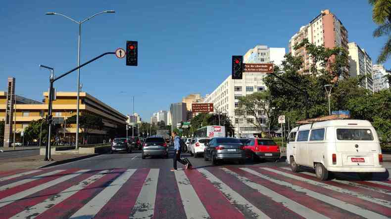 Avenida dos Andradas, em BH, com carros parados no semforo, prdios nas laterais e cu azul ao fundo. 