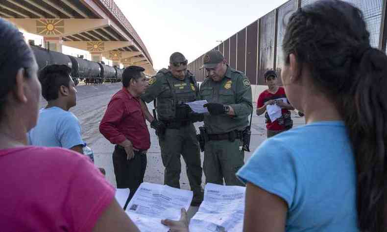 Agentes federais conferem documentao de imigrantes em El Paso, na fronteira entre Estados Unido e Mxico(foto: Paul Ratje/AFP)