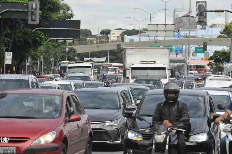 Trnsito intenso de veculos, com carros, moto e caminho