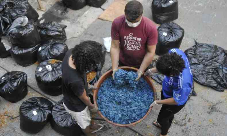 Jovens trabalhando na serragem tingida de azul