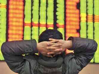 Investidor observa painel na Bolsa da China, que encerrou prego depois de aes despencarem mais de 7%. Queda derrubou papis de empresas em outras partes do mundo(foto: AFP/Photo/China Out)