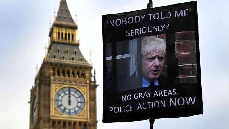 Um manifestante segura um cartaz mostrando o primeiro-ministro britânico Boris Johnson, do lado de fora do parlamento em Londres, 19 de janeiro de 2022