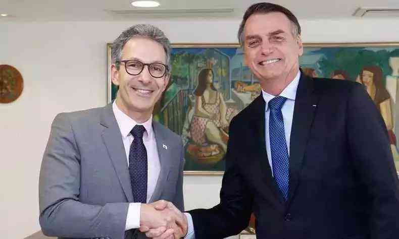 Romeu Zema e Bolsonaro dando as mos e sorrindo