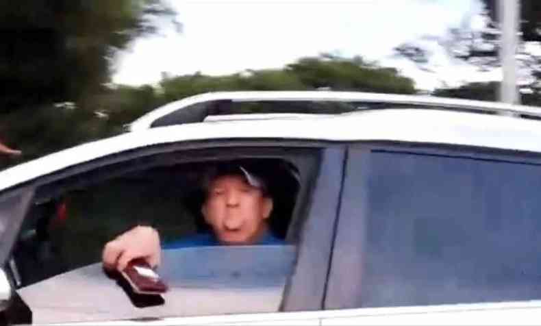 Homem colocando lngua da janela de um carro 