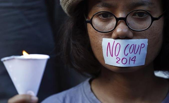 Mulher acende vela em protesto contra golpe, no centro da capital Bangkok(foto: Damir Sagolj/Reuters) Mulher acende vela em protesto contra golpe, no centro da capital Bangkok(foto: Damir Sagolj/Reuters)
