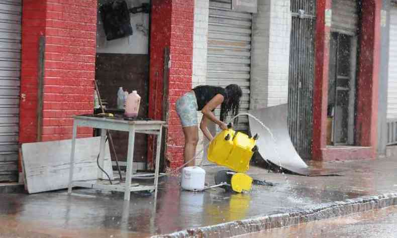 Comerciante limpa local de trabalho aps enchentes(foto: Juarez Rodrigues/EM/D.A. Press)
