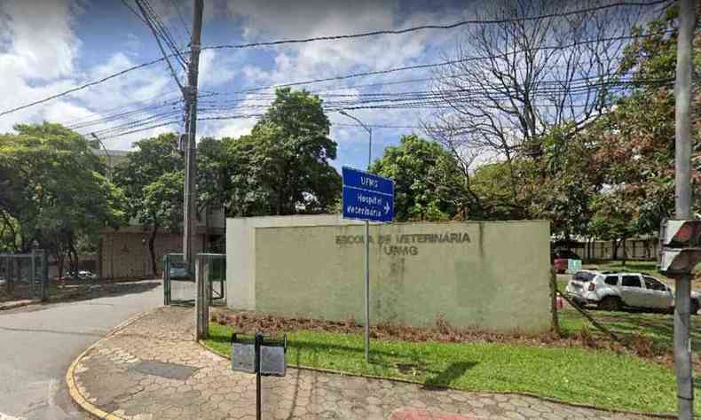 Fachada do prdio da Escola de Veterinria da UFMG. Muro verde, com gramado na frente.