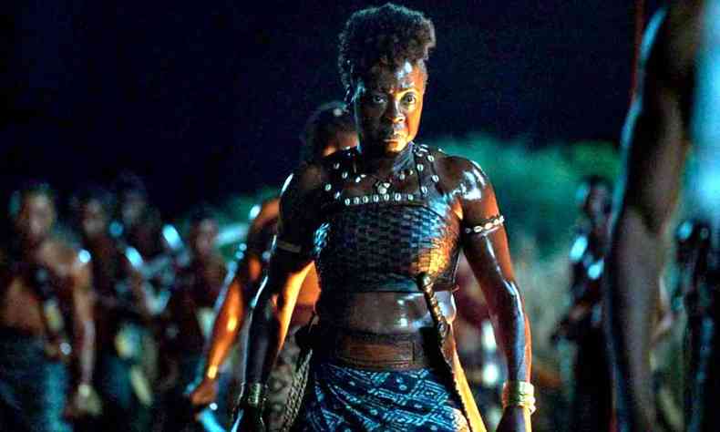 Viola Davis, dressed as a warrior, outdoors, at night, in a battle scene in The Woman King 