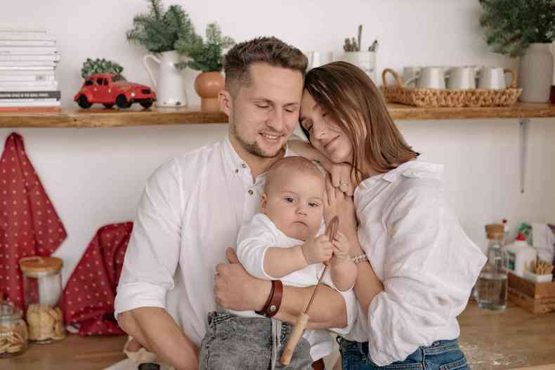 Um homem, uma mulher e um beb posam para foto