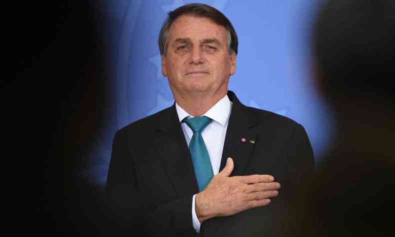 O presidente Jair Bolsonaro com a mo no peito, olhando para a cmera