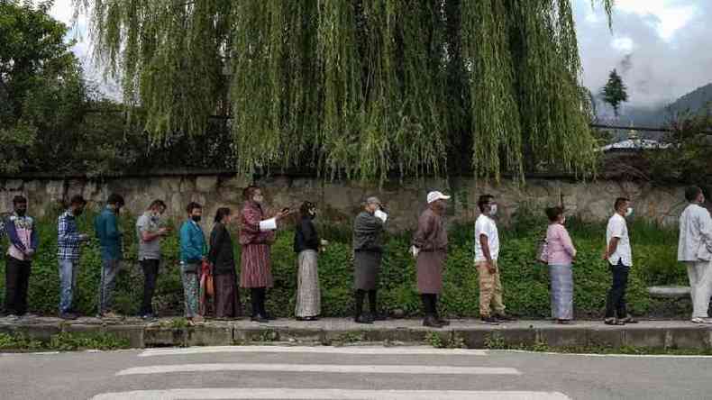 Pessoas fazem fila para receber vacina contra covid na capital Thimpu(foto: Getty Images)