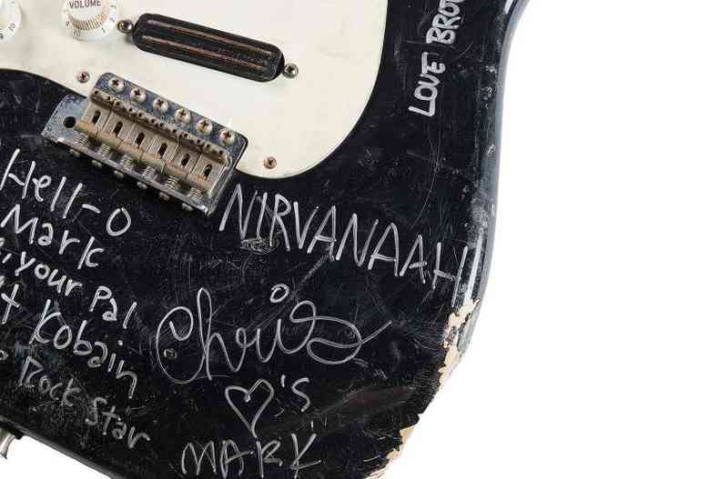 Guitarra preta com detalhes brancos tem diversas inscries feitas com caneta de tinta branca
