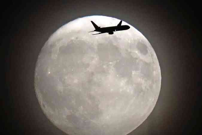 Avio comercial voa em frente a lua em direo ao aeroporto de Heathrow em Londres AFP / Adrian DENNIS 