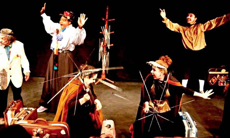 Cinco atores em cena no palco, durante a pea Capito Fracasso, levantam os braos 