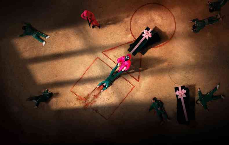 Jogador morto em um dos jogos mortais de Round 6 é arrastado para cremação em um grande pátio, onde há outros corpos.