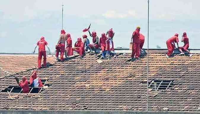 Em cima do telhado, presos tentam convencer detentos de outros pavilhes a participarem da rebelio(foto: Juarez Rodrigues/EM/D.A.Press)