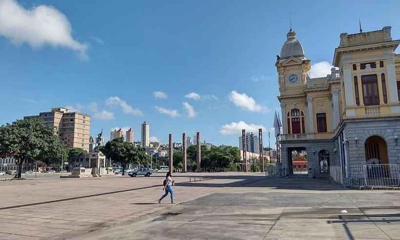 Mulher caminha na Praa da Estao vazia sob cu aberto e dia quente em belo Horizonte no Centro