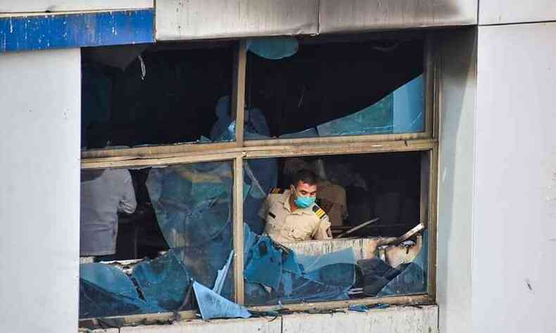 Policial verifica danos em hospital incendiado na ndia(foto: Vinamra ACHAREKAR / AFP)