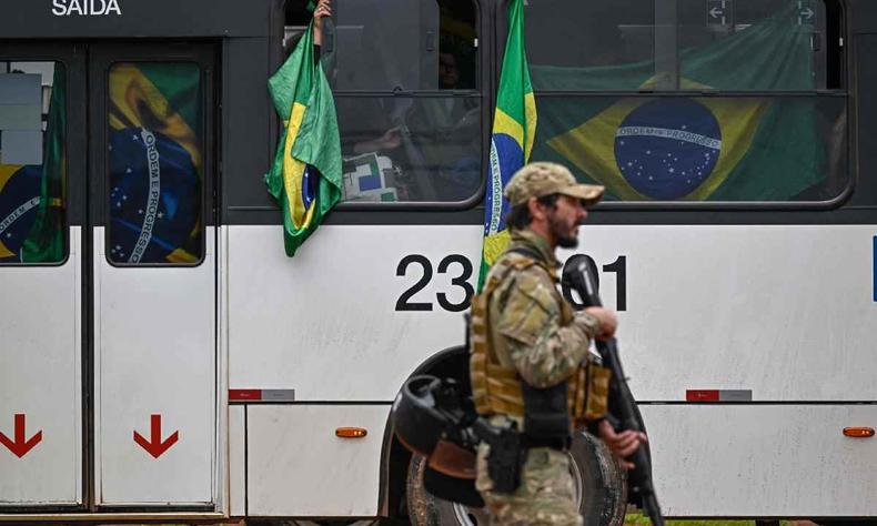 Apoiadores do ex-presidente de extrema-direita do Brasil, Jair Bolsonaro, sob custdia, so levados em nibus pelas foras policiais  sede da Polcia Federal para ter suas identidades e fichas criminais verificadas quanto  possvel implicao em atos de vandalismo durante as invases ao Congresso, palcio presidencial e Supremo Tribunal Federal, em Braslia, em 9 de janeiro de 2023, um dia aps a manifestao da turba pr-Bolsonaro