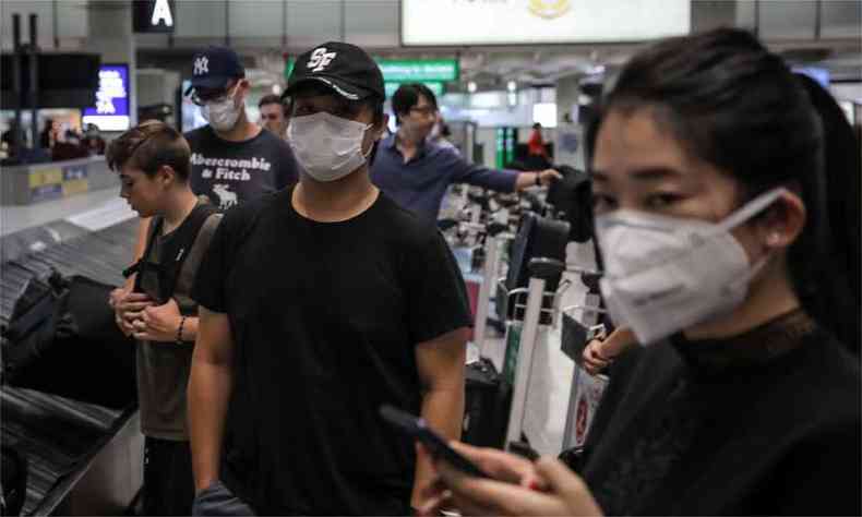 Viajantes que usam mscaras faciais na rea de desembarque no Aeroporto Internacional de Hong Kong(foto: VIVEK PRAKASH/ AFP )