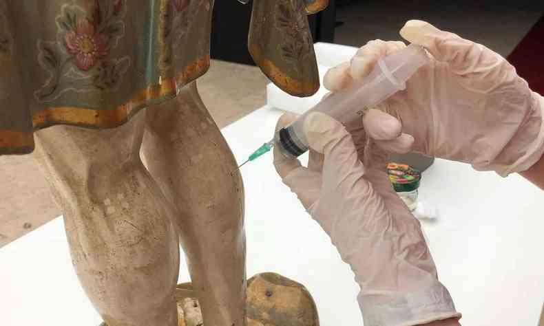 Escultura de So Manuel recebe 'injeo' durante processo de descupinizao