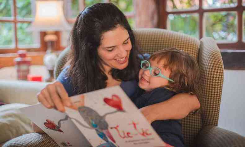 Graziela Andrade l o livro para uma de suas filhas, Helena, de 2 anos