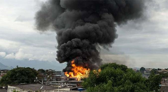 Fogo atinge resid�ncias pr�ximas ao dep�sito de combust�veis em Duque de Caxias (foto: AFP PHOTO/Yasuyoshi CHIBA )
