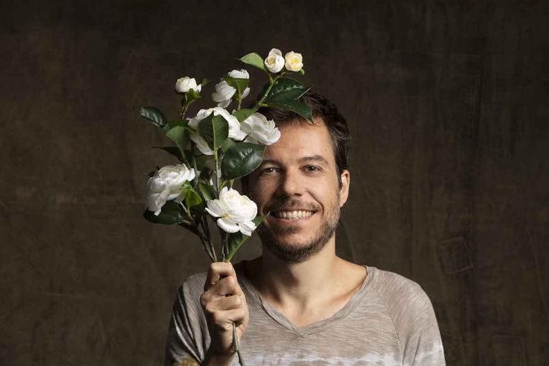 Joo Cavalcanti sorri e segura flores brancas