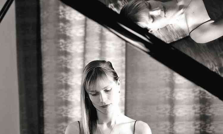 Pianista Anastasiya Evsina em frente ao piano
