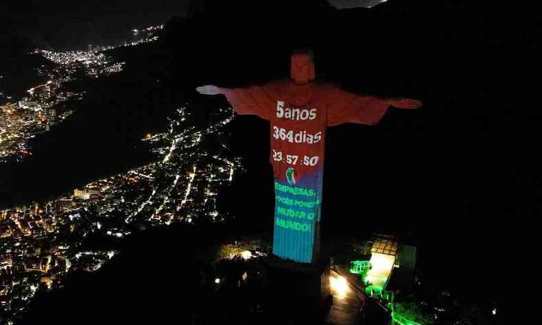 Cristo redentor com a projeo que diz '5 anos 364 dias; empresas vocs podem mudar o mundo'', com letras brancas em fundo vermelho 