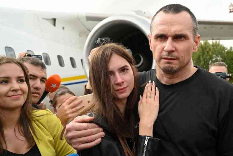 De camiseta preta, Oleg Sentsov abraça a filha Alina Sentsova no aeroporto internacional de Kiev