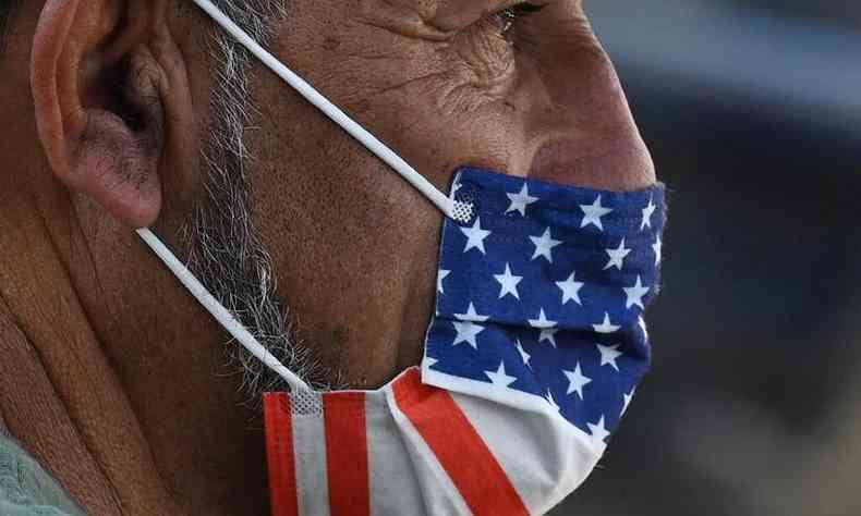 Homem usa mscara com a bandeira norte-americana no segundo dia de obrigatoriedade do uso de proteo em lugares fechados na Califrnia(foto: Robyn Beck / AFP)