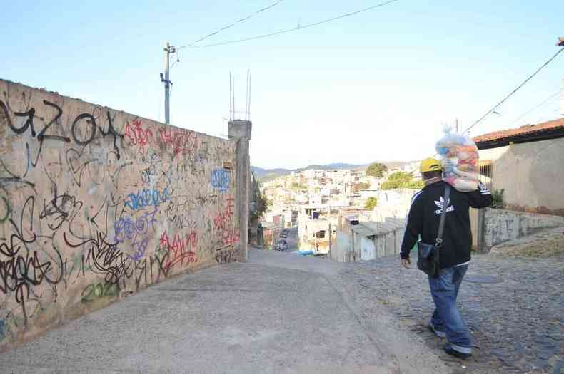 Jlio, lder comunitrio no Alto Vera Cruz, anda na rua carregando uma cesta bsica sobre o ombro