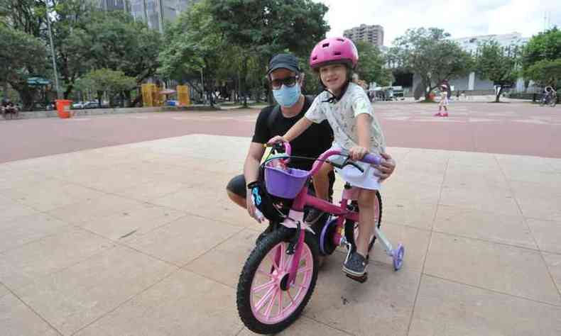 Na Praa da Assembleia, Pedro Henrique de Souza e Silva com a filha Laura Hara Silva que foi presenteada com uma bicicleta