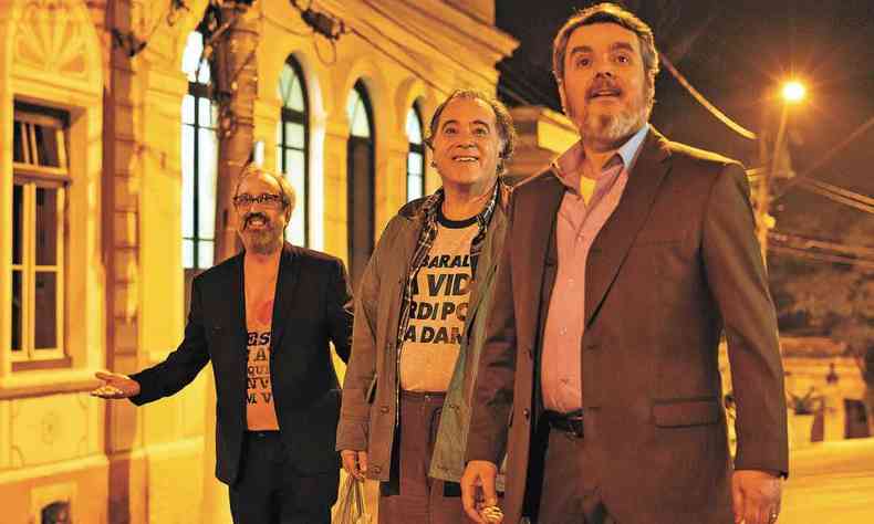 Os atores Ary Frana, Tony Ramos e Cssio Gabus Mendes, de p, em espao pblico  noite, olham para ponto fora de quadro e sorriem em cena de 45 do segundo tempo