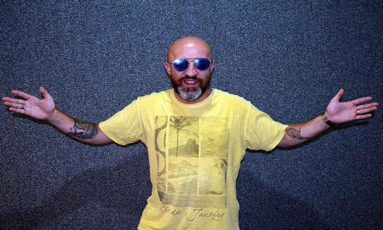 de �culos e camiseta amarela, carpinejar abre os bra�os e sorri